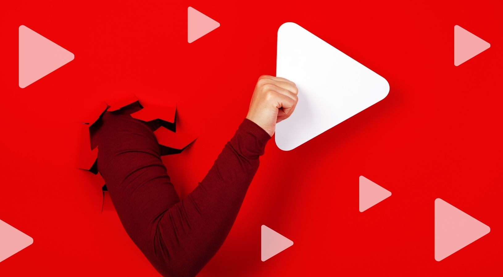 an arm breaking through a paper wall to grab play button